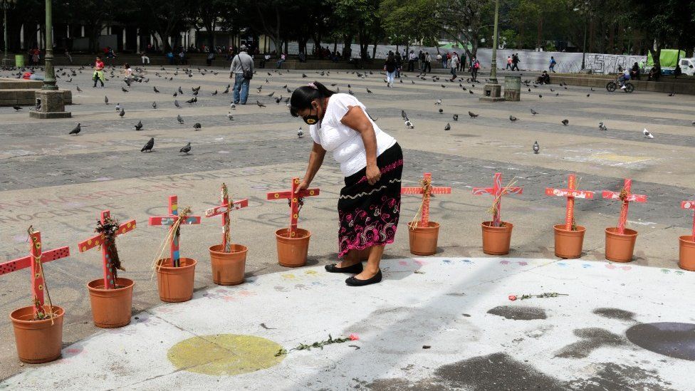 A woman tends to the monument in Guatemala City