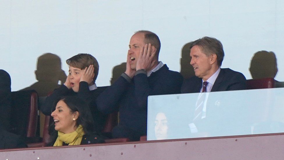 The Prince of Wales with Prince George of Wales and Aston Villa chief executive Christian Purslow (right) in the stands during the match