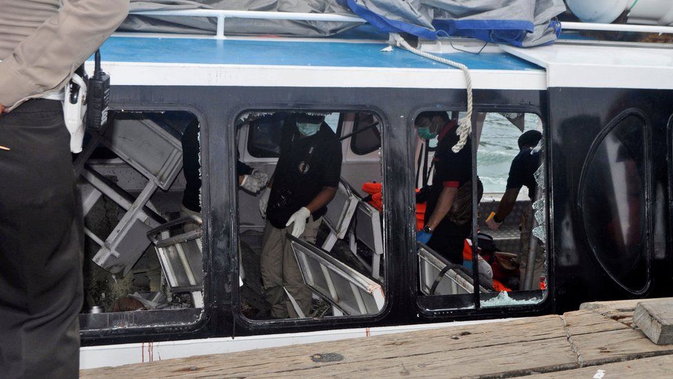 Police investigators examine the Gili Cat 2 boat following an explosion off Bali, Indonesia, on 15 September