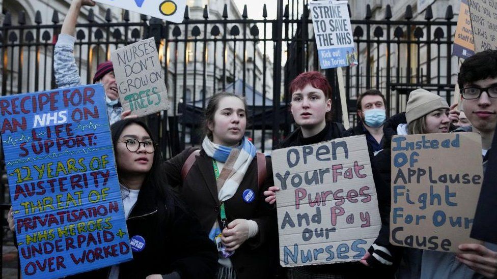 NHS nurses hold signs during a strike over pay