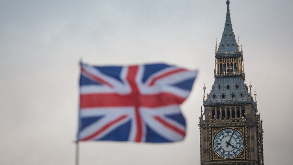 A Union flag flutters in front of the Elizabeth Tower, commonly known as Big Ben