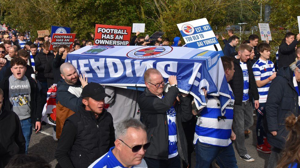 Reading FC fans carry a coffin to protest against the club's owner