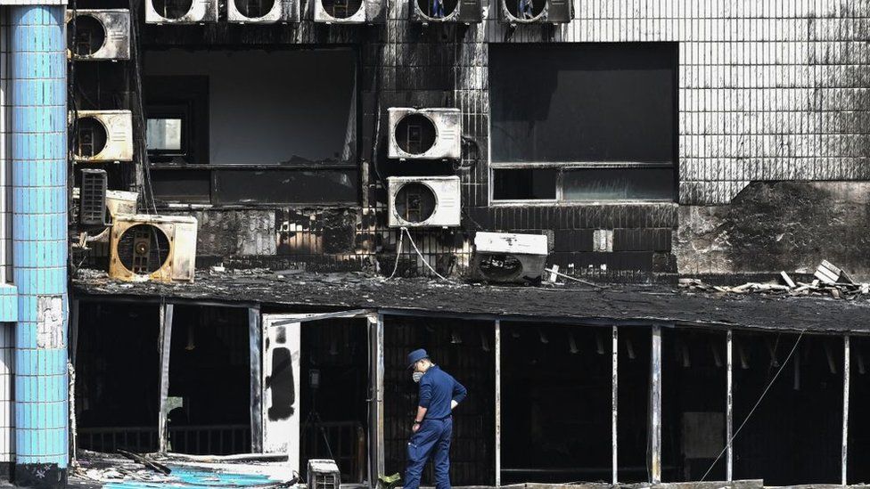 An investigator inspects the damage caused by a fire at the Changfeng Hospital in Beijing