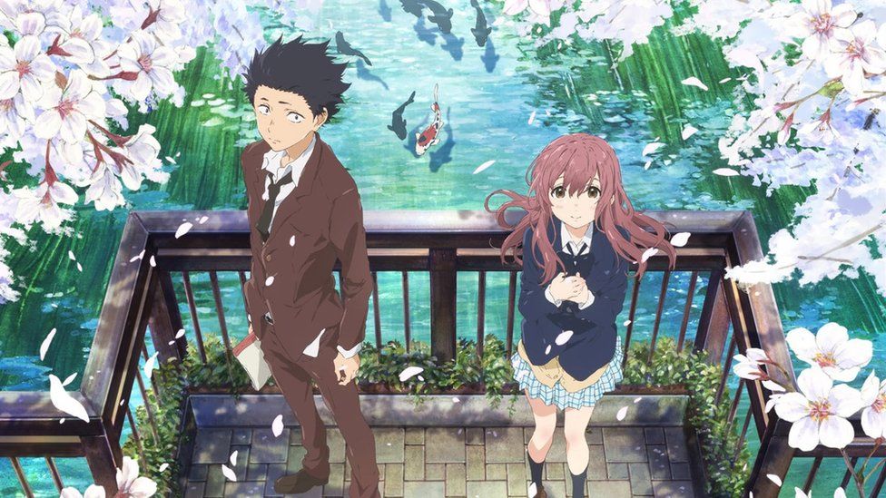 A still image shows two teenagers standing on a bridge over a koi pond, with the girl looking hopefully upward, while the boy is turned slightly away