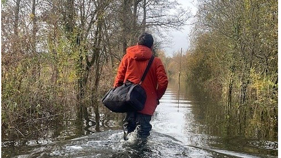 Man walking along a flooded road