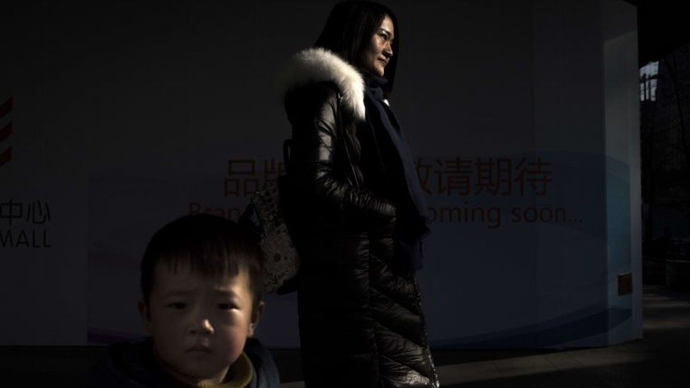 In this photo taken on January 5, 2016, Li Wenzu, the wife of detained Chinese human rights lawyer Wang Quanzhang, and her son Qiaoqiao pose for a photograph in Beijing.