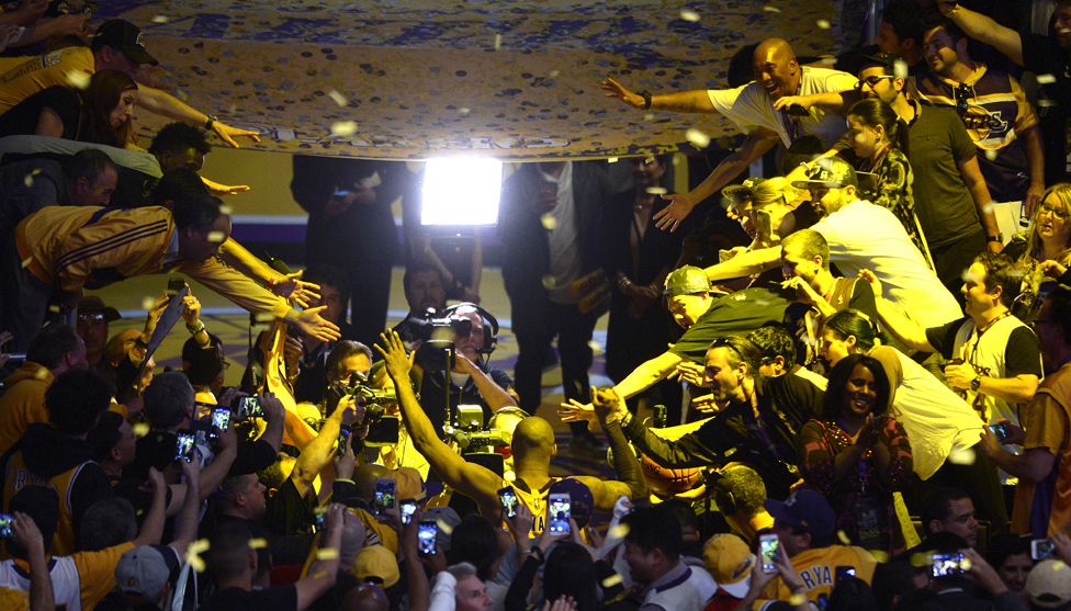 Fans reach out to touch Kobe Bryant as he leaves the court after defeating the Utah Jazz in 2016.