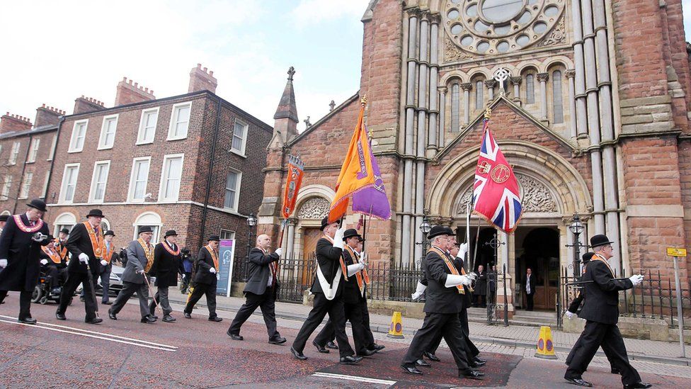 Orangemen walk past St Patrick's Church in Belfast