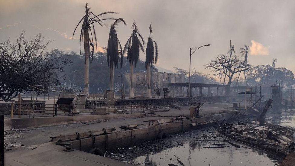 A charred boat lies in the scorched waterfront after wildfires fanned by the winds of a distant hurricane devastated Maui's city of Lahaina