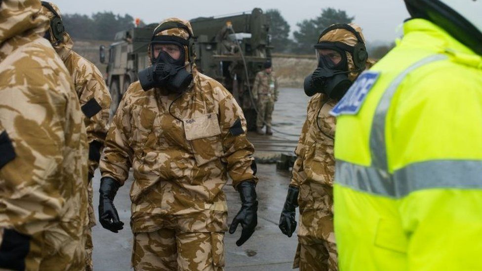 Military personnel pictured in gas masks at Winterbourne Gunner before deployment to Salisbury