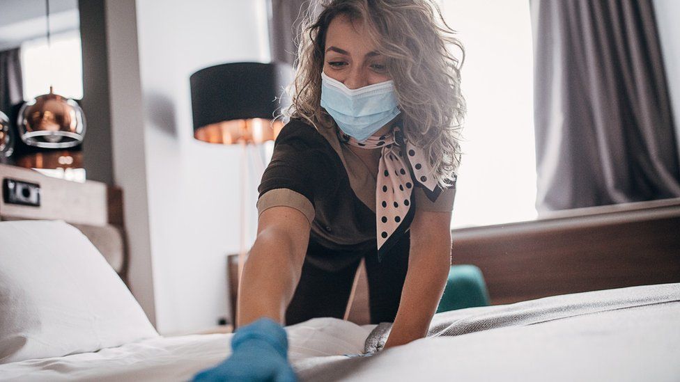 Woman making up hotel bed