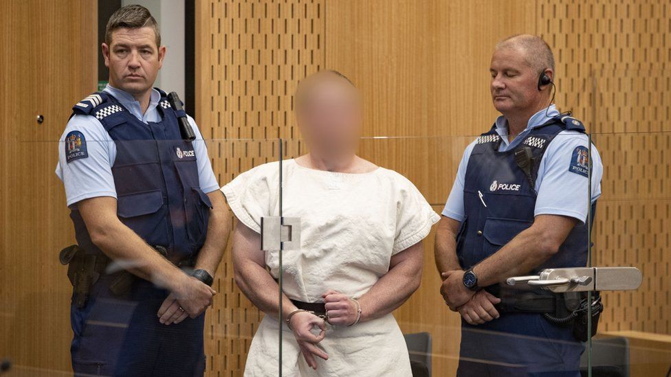 Brenton Tarrant flashed a hand sign as he appeared in court on Saturday charged with murder