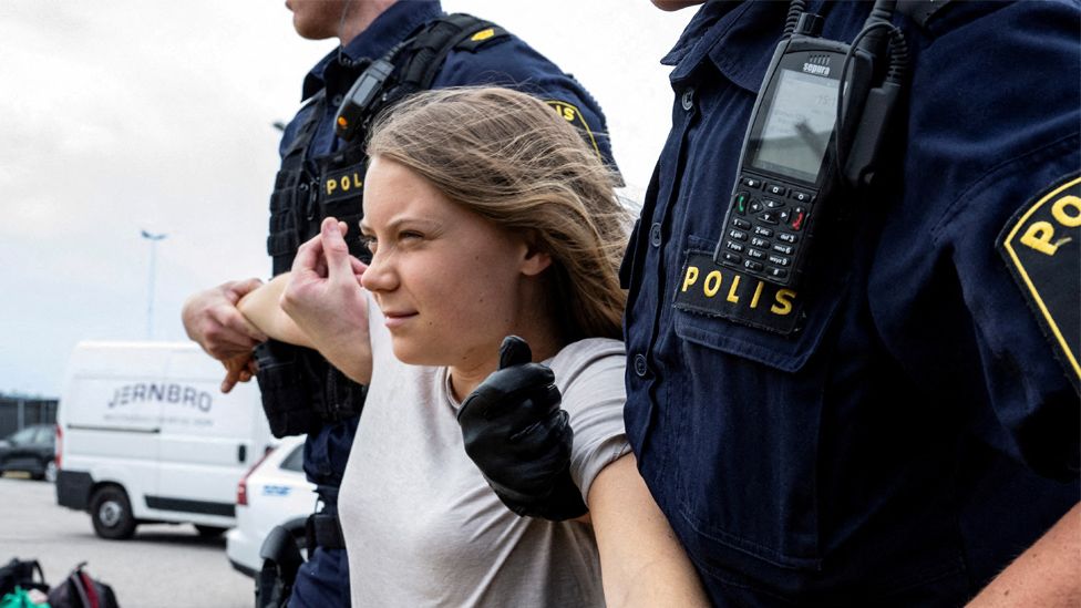 Police officers carry Swedish climate activist Greta Thunberg away from a protest