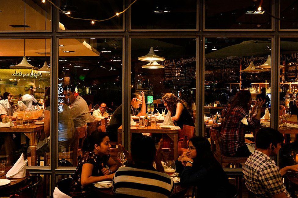 In this photograph taken on May 11, 2016, people eat food inside a restaurant in DLF Cyber City area of Gurgaon, 32 kilometres southwest of the capital New Delhi. The satellite town of Gurgaon near the Indian capital is home to scores of top multinational companies, and the influx of foreign capital has brought with it gleaming shopping malls enjoyed by India's rising middle class seeking an outlet for their disposable income