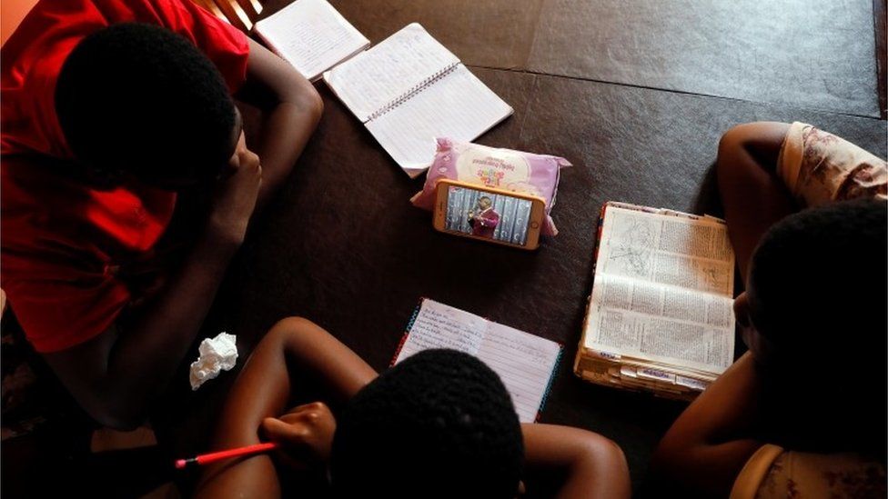 Teenagers watch the live broadcast of church service from home as all religious gatherings are suspended over concerns of the spread of coronavirus disease (COVID-19), in Accra, Ghana, March 22, 2020.
