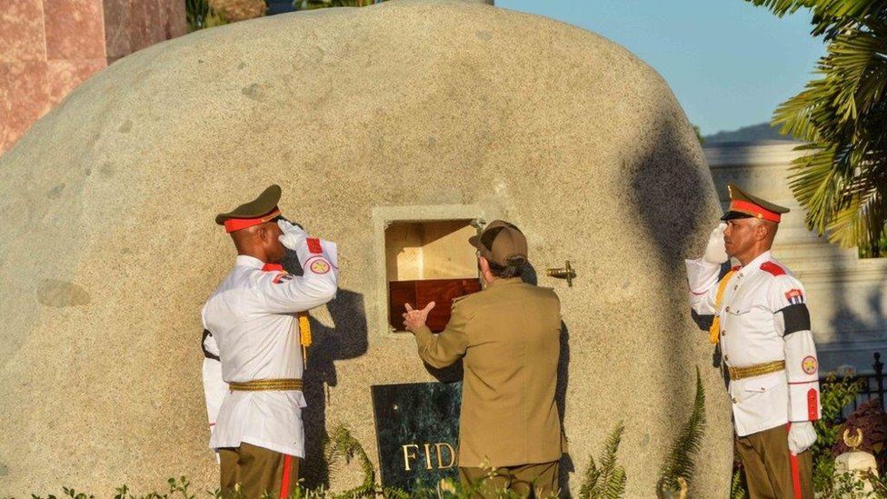 Cuban President Raul Castro places the urn with the ashes of his brother Fidel Castro in his tomb at the Santa Ifigenia cemetery in Santiago de Cuba