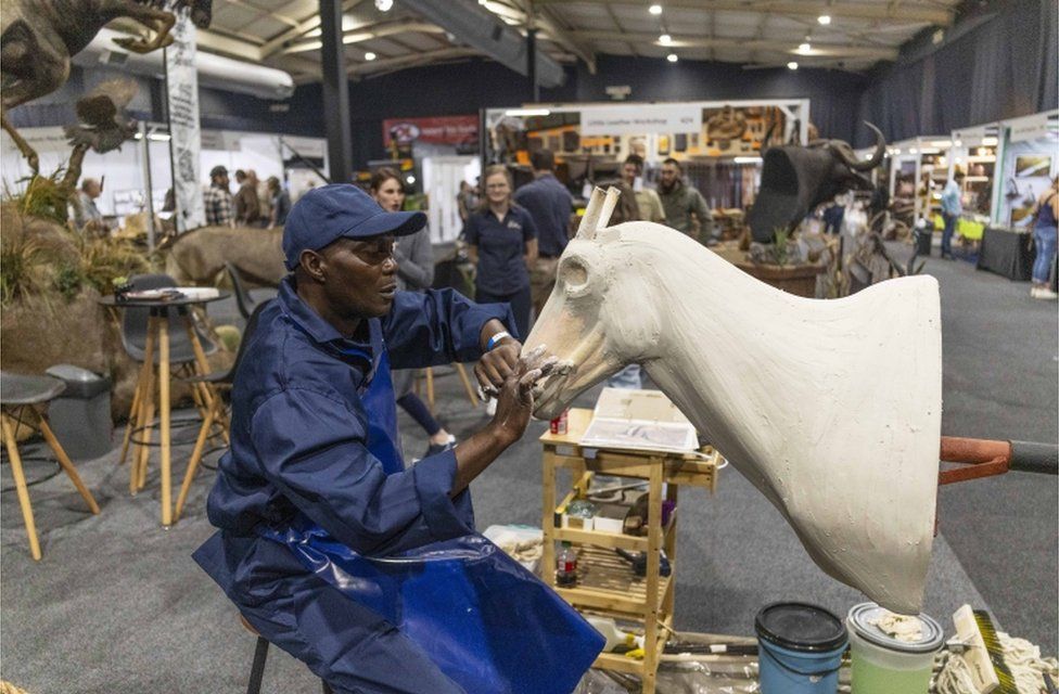 A taxidermy worker works on an antelope during the annual HuntEX expo.