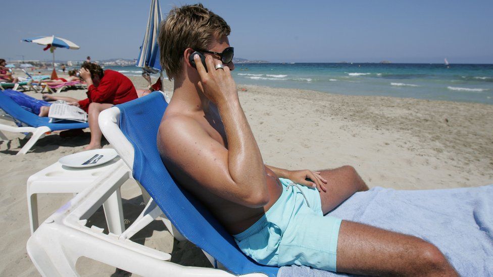 man on phone on beach