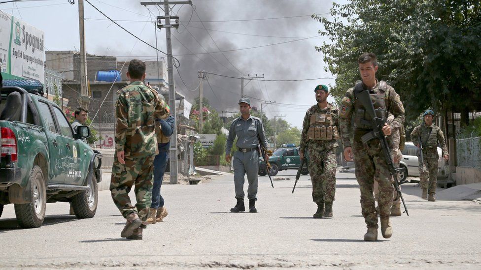 Afghan security officials secure the road outside the scene of the attack