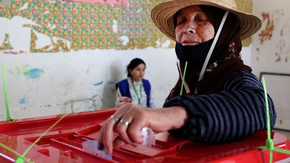 A Tunisian woman votes during a referendum on a draft constitution put forward by the country's President, at a polling station in Kasserine, on July 25, 2022