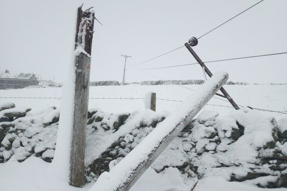 Broken power pole down in the snow