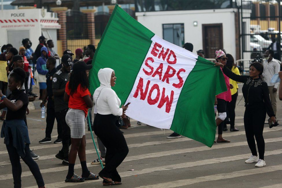 Protesters hold a Nigerian flag