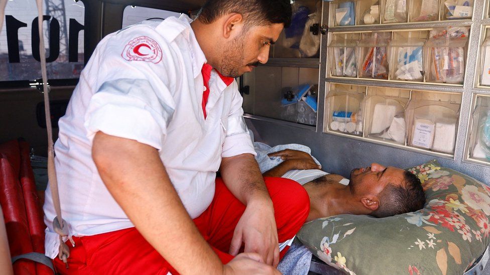 A medic speaks to an injured Palestinian inside an ambulance at Gaza's Rafah border crossing with Egypt (1 November 2023)