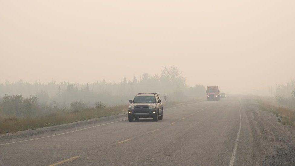 Vehicles leave Yellowknife on the only highway in or out of the city after a state of emergency was declared due to the proximity of a wildfire, in Yellowknife, Northwest Territories