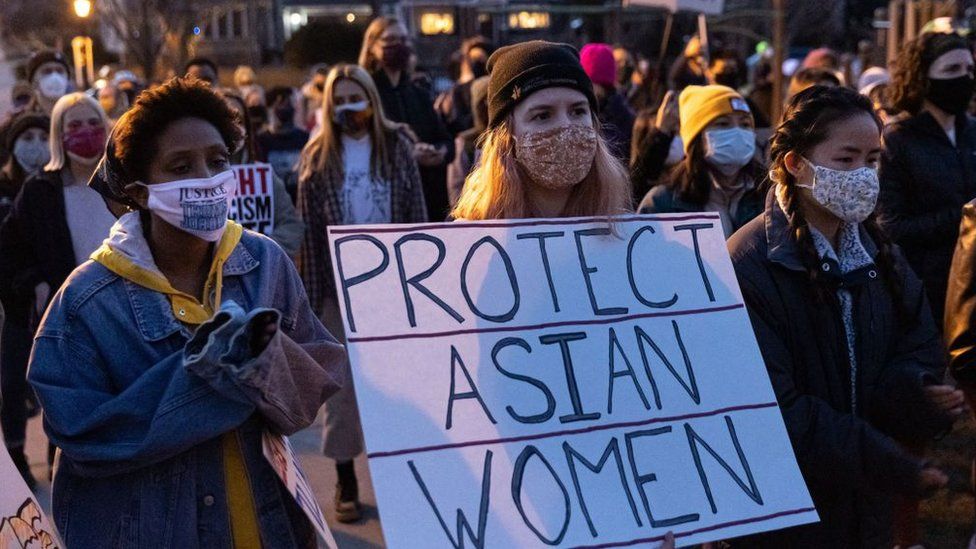 A woman holds a sign during the "Asian Solidarity March" rally against anti-Asian hate in response to recent anti-Asian crime on March 18, 2021 in Minneapolis, Minnesota