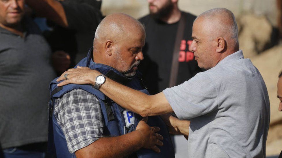 Wael Al-Dahdouh (left) attends the funeral for members of his family