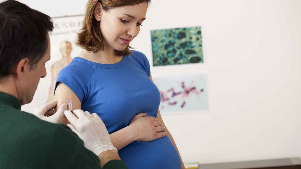 A simulated photo of a pregnant woman receiving a vaccination