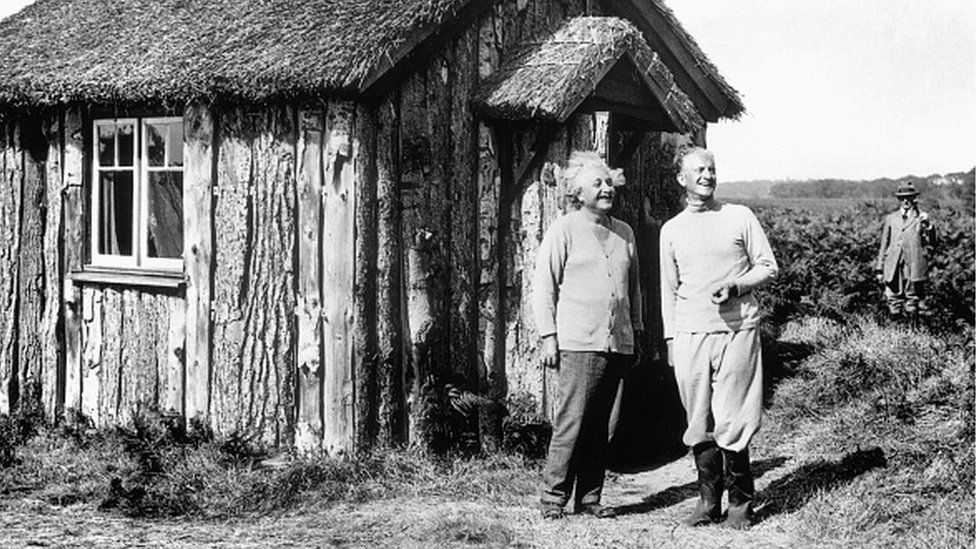 Albert Einstein with Oliver Locker-Lampson under armed guard outside his log cabin in Roughton Heath, Norfolk in 1933