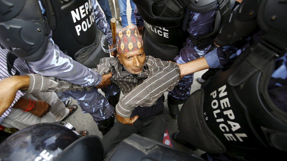 A Hindu activist blocking a road is carried away by police during a protest rally demanding Nepal be declared a Hindu state in the new constitution, near the parliament in Kathmandu, Nepal, September 1, 2015