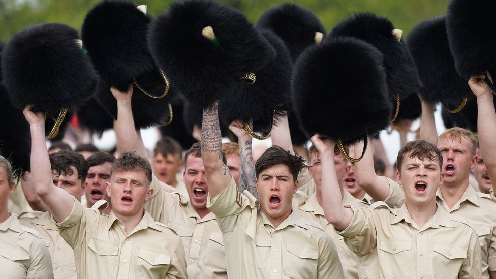 Members of the Welsh Guards remove their head dress