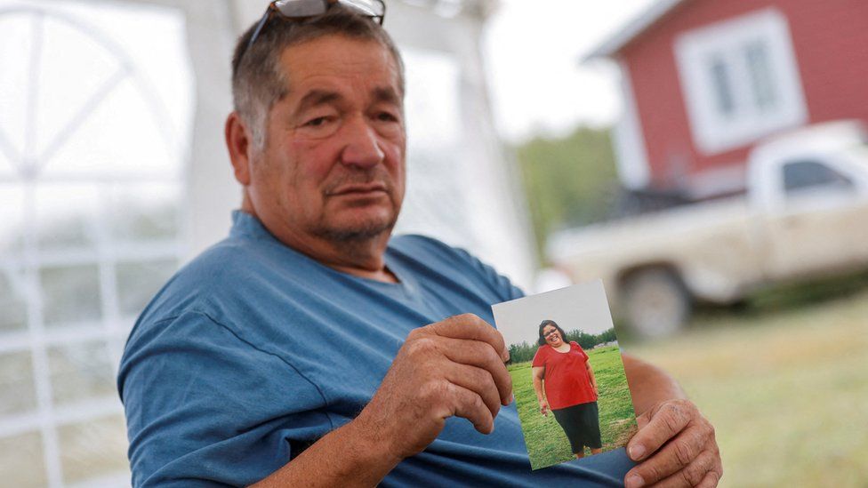 Daryl Burns holds a photo of his sister, Gloria