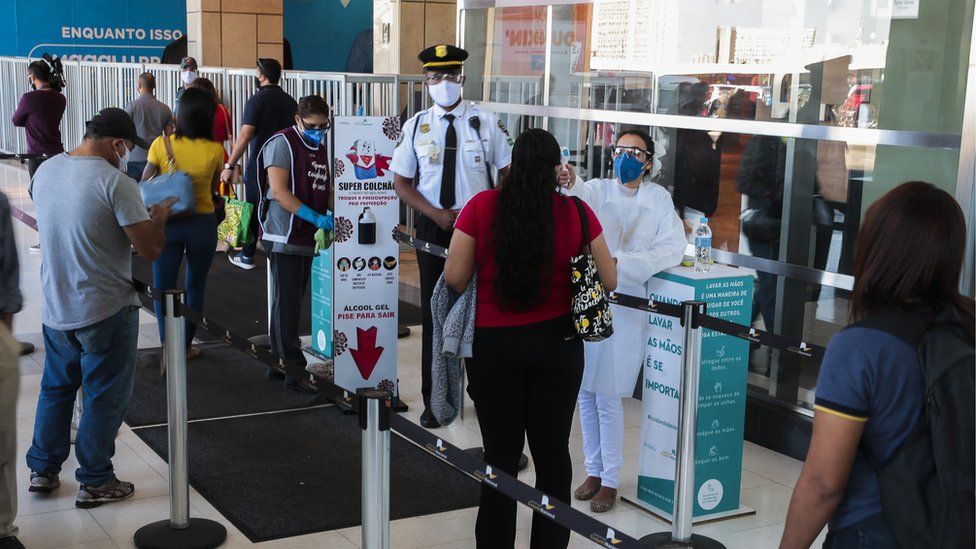 pessoas em area de controle de temperatura depois de governo do Distrito Federal autorizar a abertura de shoppings