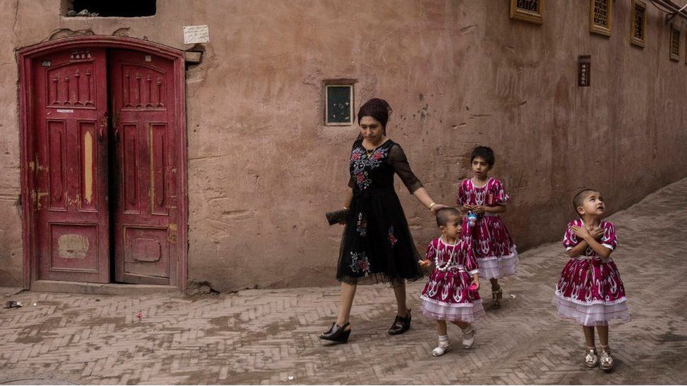 An ethnic Uyghur woman walks with her children on June 28, 2017 in the old town of Kashgar, in the far western Xinjiang province, China.