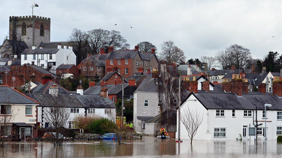 St Asaph flooding in Novermber 2012, showing town with cathedral in background and a boat rescue