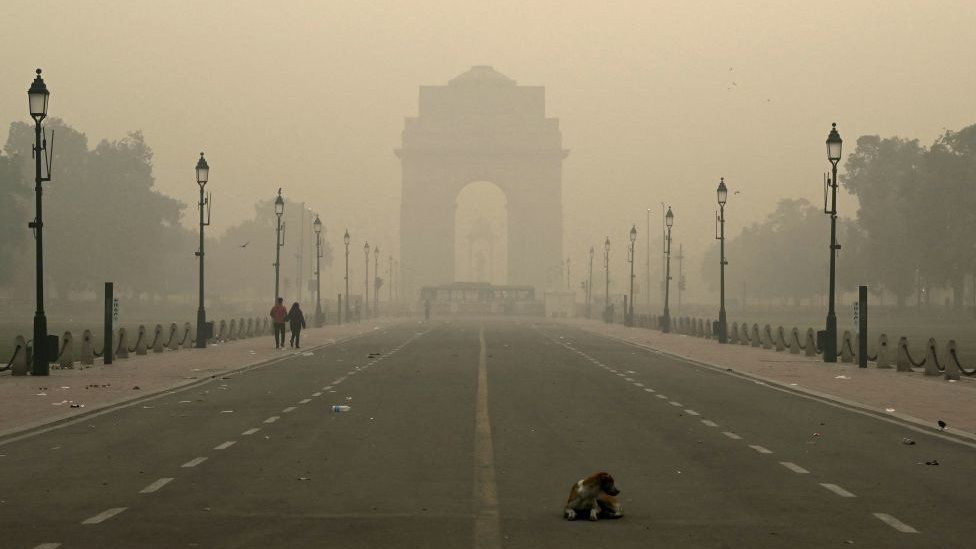 Pedestrians walk along the Kartavya Path in front of the India Gate amid heavy smoggy conditions in New Delhi on November 13, 2023. Delhi regularly ranks among the most polluted major cities on the planet, with a melange of factory and vehicle emissions exacerbated by seasonal agricultural fires. (Photo by Money SHARMA / AFP) (Photo by MONEY SHARMA/AFP via Getty Images)