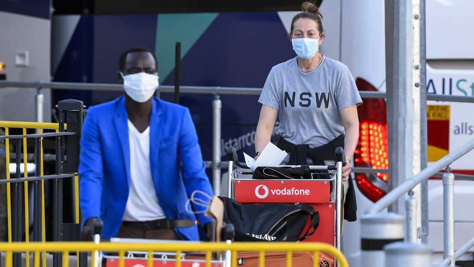 Passengers wearing face masks arriving back at Sydney Airport in May