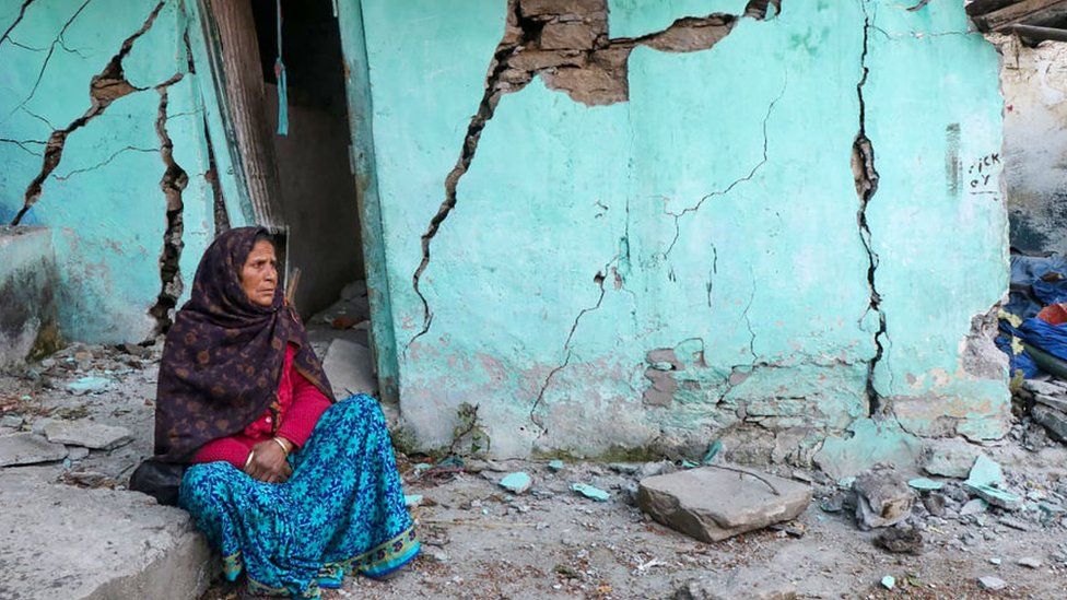 Женщина сидит у треснувшей стены своего дома в Джошимате в районе Чамоли индийского штата Уттаракханд, 10 января 2023 года.