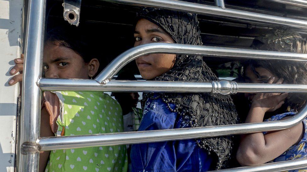 Women and children seen in a police vehicle after trying to flee (file photograph)