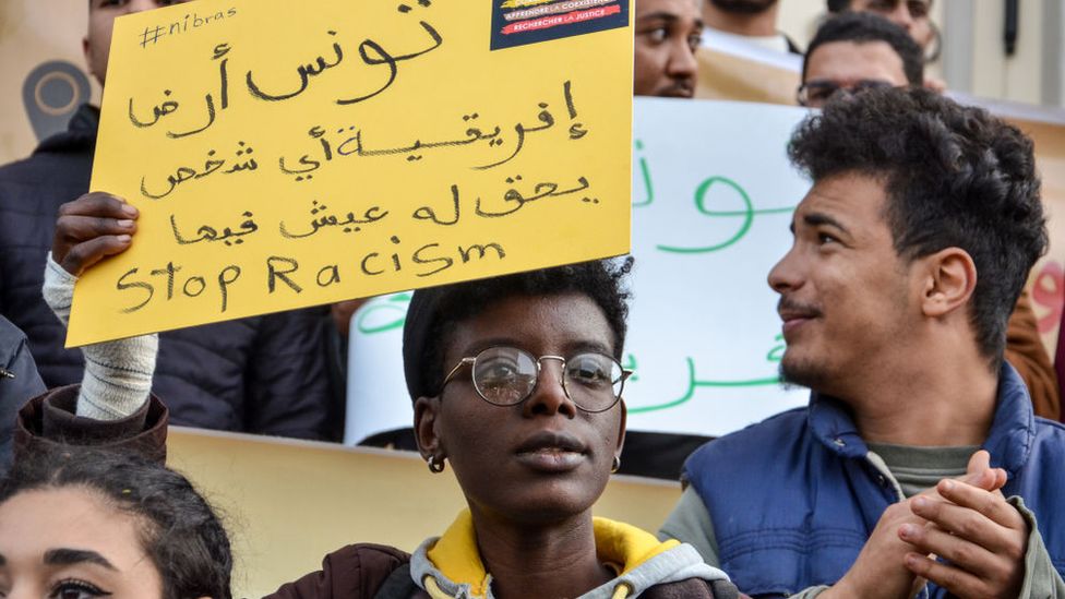 A person is holding a sign during a demonstration in Tunis to protest against racism and against President Saied latest comments about the urgency to tackle illegal immigration in the country.