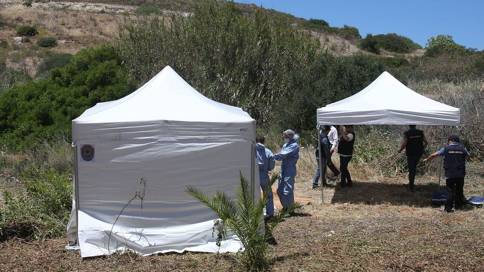 Forensic police officers prepare to examine an area of wasteland to search for Madeleine McCann in the town of Praia da Luz, Portugal