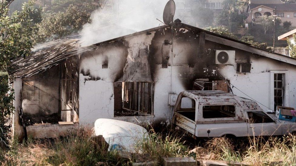 A picture taken on July 16, 2021 shows a house destroyed after angry mobs set fire to homes in Duffs Road near Phoenix