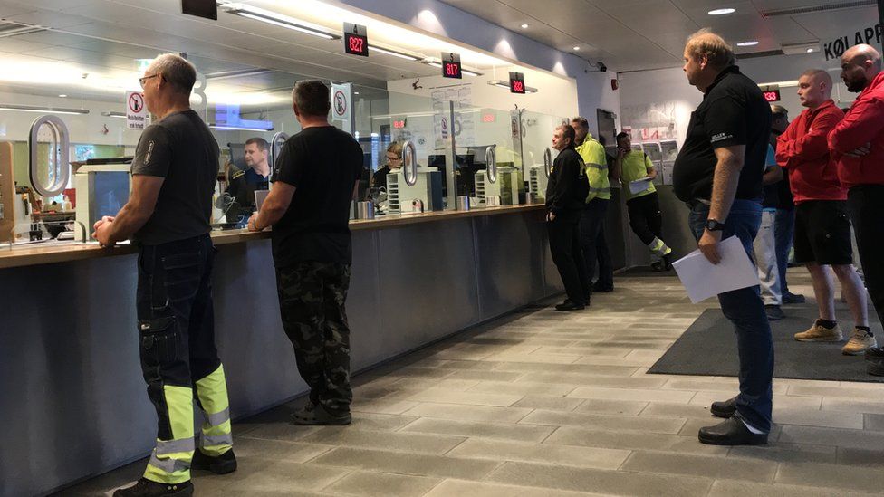 People queuing inside a Norwegian customs office