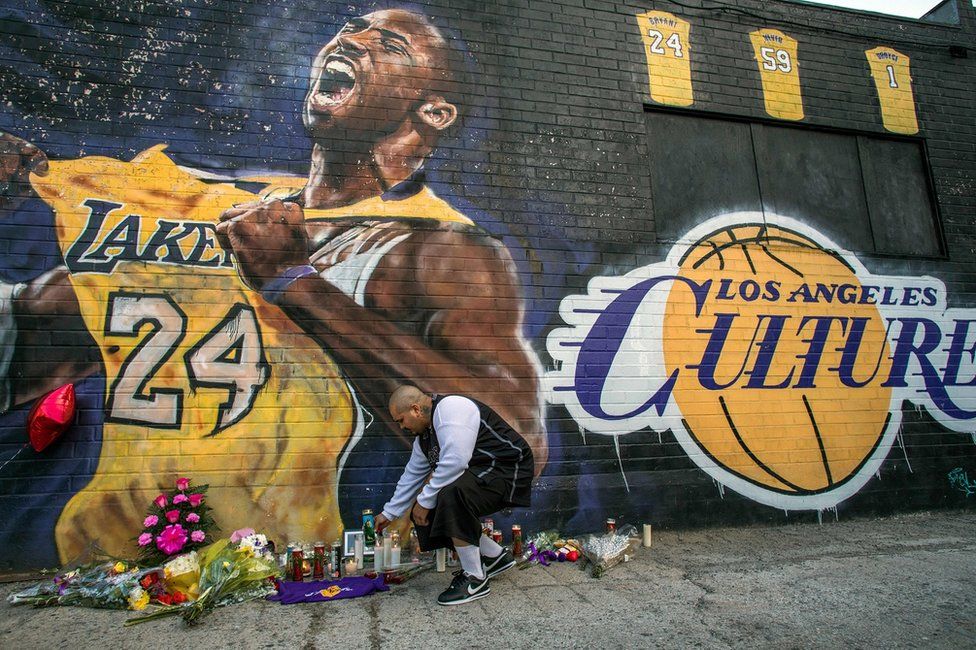Flowers are laid next to a mural of the player in downtown Los Angeles.