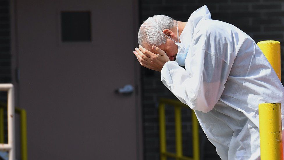 A medical personnel rubs his face outside the Wyckoff Heights Medical Center on April 07, 2020