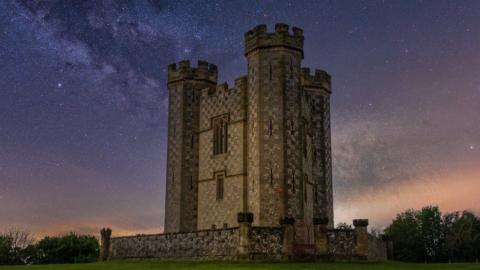 A tower is shown surrounded by a starry sky