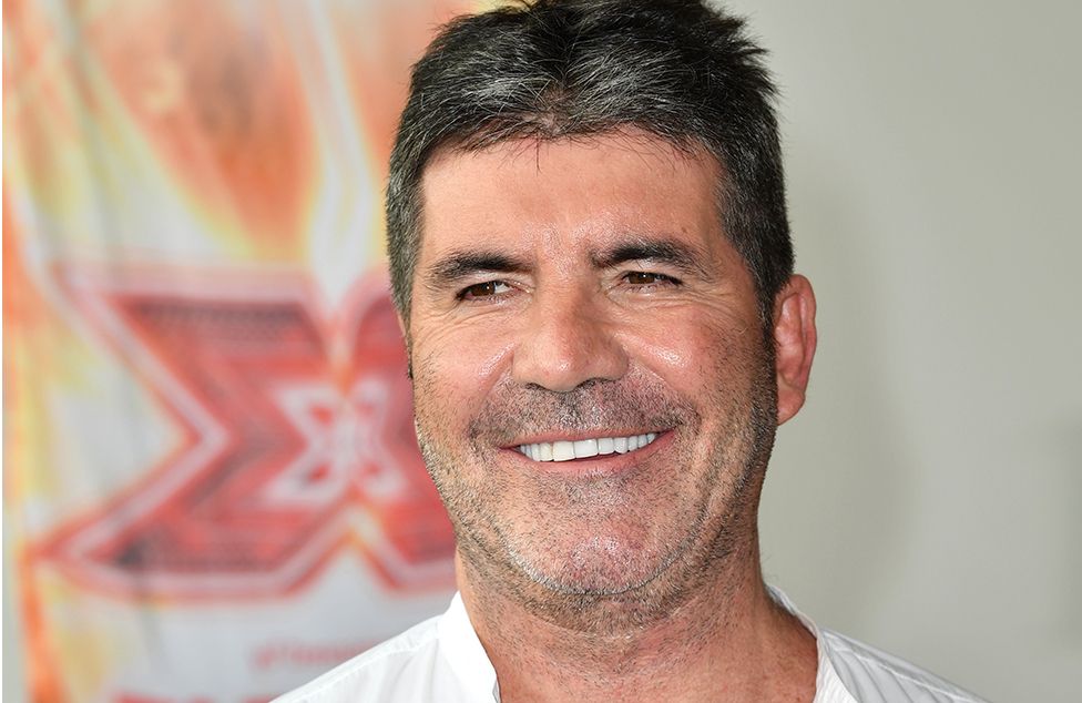 Head shot of Simon Cowell in front of the X Factor logo